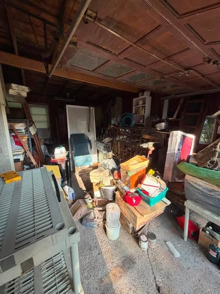 Old wooden garage packed wall to wall before an estate cleanout