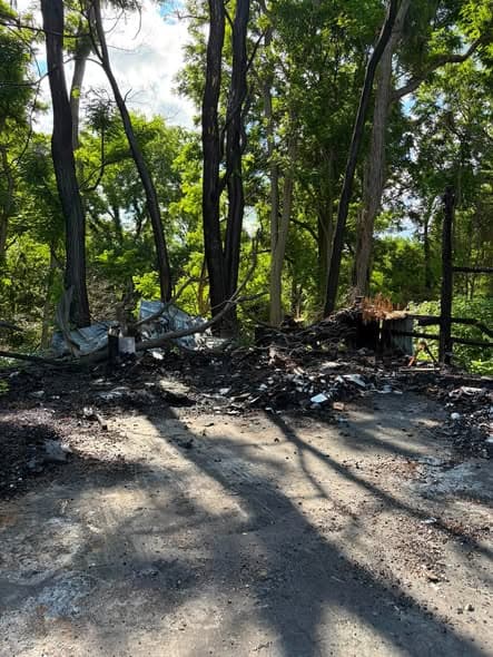 Outbuilding torn down with debris staged on the pad